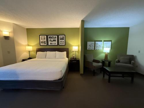 a bedroom with a large bed and a chair at SureStay by Best Western Roseburg in Roseburg