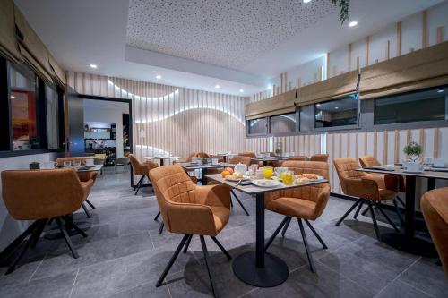 un restaurant avec des tables et des chaises dans une salle dans l'établissement Best Western Plus Central Park Hotel, à La Rochelle