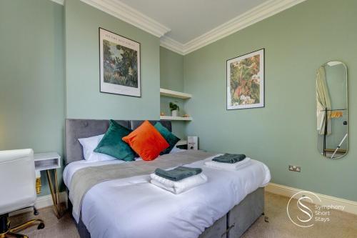 ein Schlafzimmer mit einem Bett und einem Spiegel in der Unterkunft Leamington Spa Warwick Place Apartments in Leamington Spa
