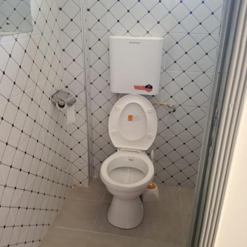 a bathroom with a white toilet in a stall at Dadesa place in Kakamega