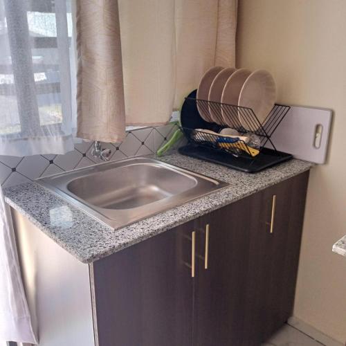 a kitchen counter with a sink and a window at Dadesa place in Kakamega