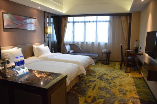 a hotel room with a large bed and a television at Ramada Foshan Hotel in Foshan