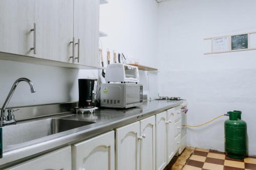 a kitchen with a sink and a microwave at Origen Hostel Jardín in Jardin