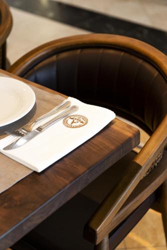 een tafel met een servet met een vork en mes bij Iliria Internacional Hotel in Durrës