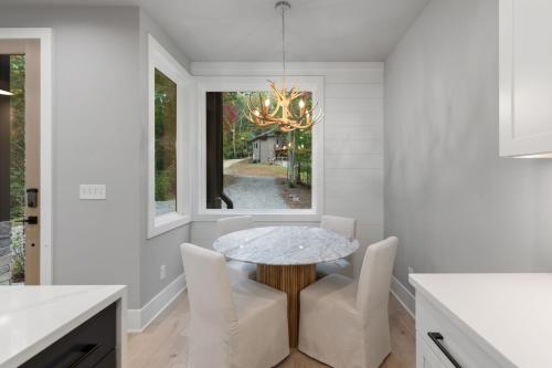 Mashburn MillSapphire Skies的一间有桌子、椅子和窗户的餐厅