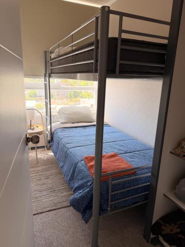 um quarto com um beliche e uma colcha azul em 2 habitaciones 1 baño- a pasos de restaurantes centros comerciales em Rancagua