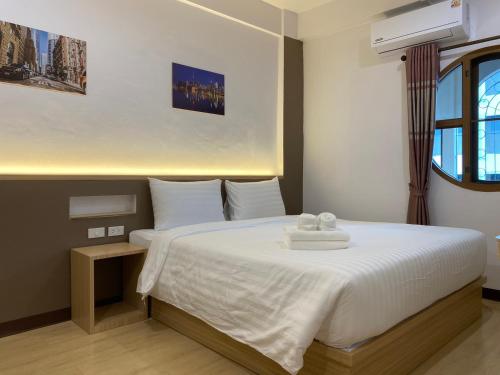a bedroom with a bed with two towels on it at Starhouse in Hat Yai
