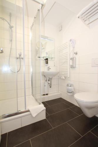 a bathroom with a shower and a sink and a toilet at Apartment Hotel am Sand 24H Self Check-in in Hamburg