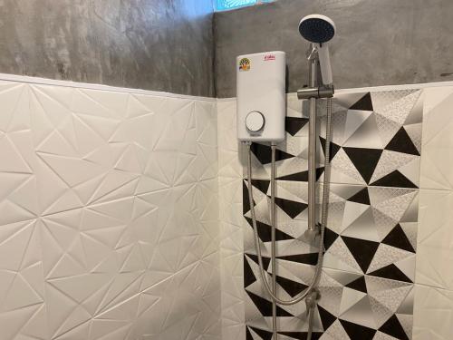 un bagno con doccia e piastrelle bianche e nere di Starhouse a Hat Yai