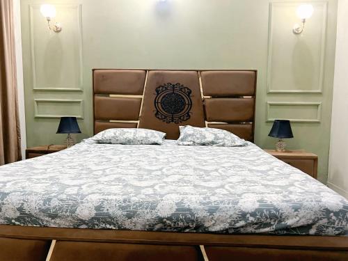 a bedroom with a large bed with two lamps on tables at Cozy Villa's in Rawalpindi