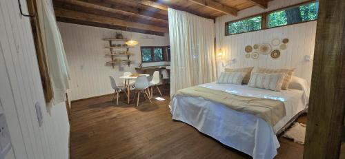 una camera da letto con un letto e un tavolo con sedie di MONTE CABAÑA San Clemente a San Clemente