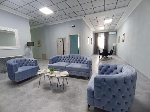 two blue couches and a table in a room at Lider Hotel Tashkent in Muruntau