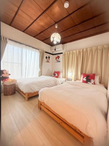 a bedroom with two beds and a window at YAHouse in Chiba