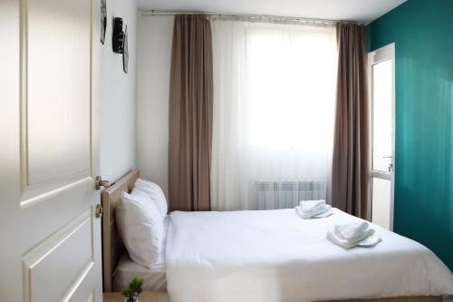 a bedroom with a white bed and a window at Domel Yerevan Moskovyan 28 in Yerevan