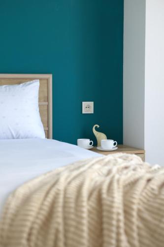 a bedroom with a bed with two cups and a table at Domel Yerevan Moskovyan 28 in Yerevan