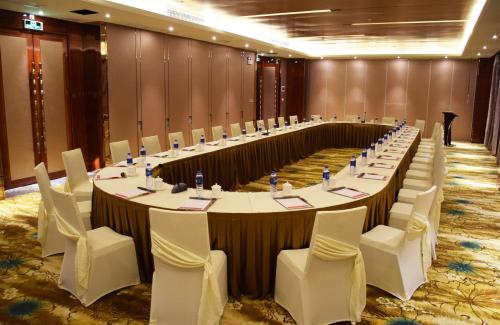 a large meeting room with a long table and chairs at Ramada Foshan Hotel in Foshan