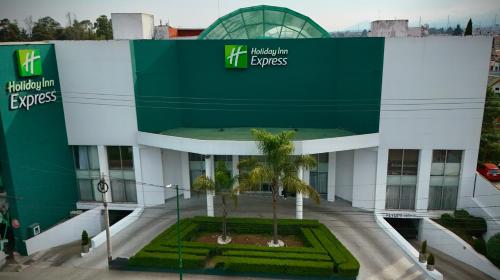 a building with a palm tree in front of it at Holiday Inn Express Toluca by IHG in Toluca
