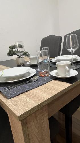 a wooden table with plates and wine glasses on it at Haus Vranjes in Rosenau am Hengstpass