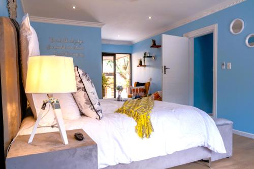 ein Schlafzimmer mit einem großen weißen Bett mit blauen Wänden in der Unterkunft The Hemingway House 14 Resort Pool in Benoni
