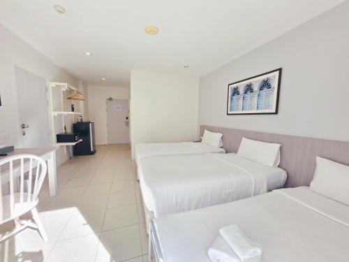 a hotel room with two beds and a kitchen at Recenta Phuket Suanluang by Deevana in Phuket