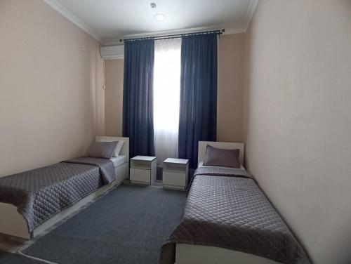 a room with two beds and a window at Lider Hotel Tashkent in Muruntau
