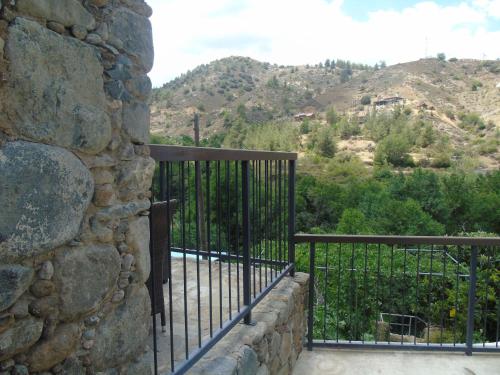 a balcony with a stone wall and a iron fence at Enipnion Apartments in Kakopetria