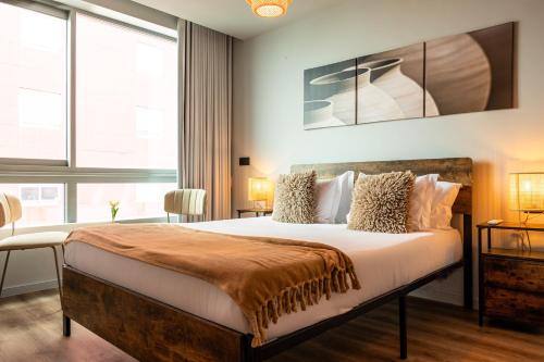 a bedroom with a large bed and a large window at Extra Large 2BR Apartment Next to Metro Station in Bicas