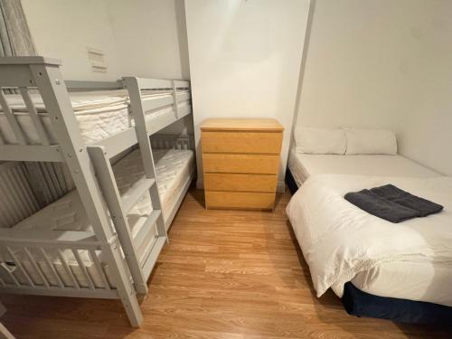 ein Schlafzimmer mit zwei Etagenbetten und Holzboden in der Unterkunft Comfort rooms near City Airport in London