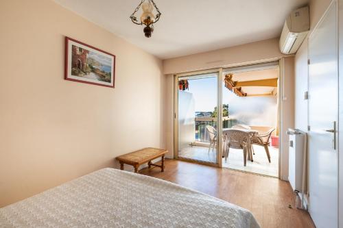 a bedroom with a bed and a view of a table at meublé tourisme 3 étoiles vue mer in Golfe-Juan