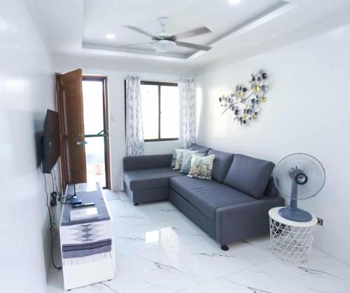 ein Wohnzimmer mit Sofa und Fernseher in der Unterkunft Mommy Irenes Place in Antipolo