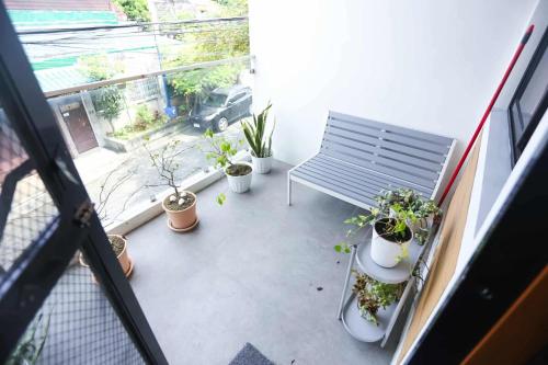 einen Balkon mit einer Bank und Topfpflanzen darauf in der Unterkunft Mommy Irenes Place in Antipolo