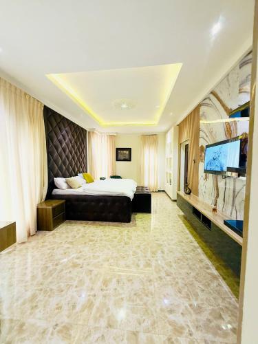 Un dormitorio con una cama grande y un televisor de pantalla plana. en The bloom apartment, en Mama