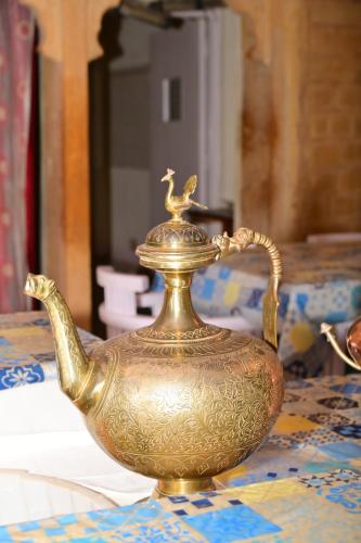 een gouden theeketel die op een tafel staat bij Himmatgarh Palace Heritage Boutique Hotel in Jaisalmer