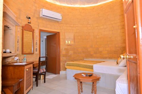 Un dormitorio con una cama y un baño con lavabo. en Himmatgarh Palace Heritage Boutique Hotel, en Jaisalmer