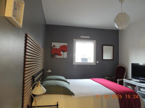 a bedroom with a bed and a window at Les Coquelicots Chambre d' hote avec grand lit et salle d'eau privative pour une persone ou un couple in Vern-sur-Seiche