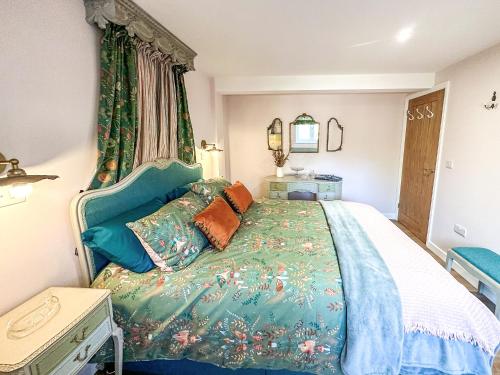 ein Schlafzimmer mit einem Bett mit einer grünen Bettdecke in der Unterkunft Talltrees - Uk42842 in Uplowman