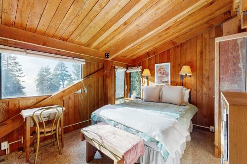 ein Schlafzimmer mit einem Bett in einem Holzzimmer in der Unterkunft Schooner in Sea Ranch