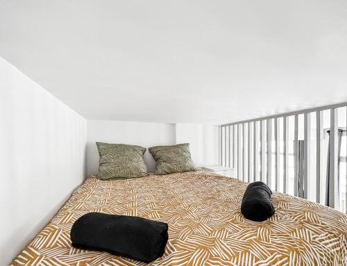 a bedroom with a large bed with two pillows at Loft cosy, Canapé-lit & Mezzanine, cœur de Cambrai in Cambrai