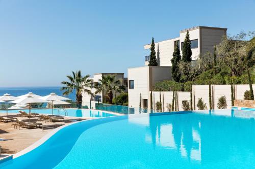 a large blue swimming pool next to a building at Ikos Oceania in Nea Moudania