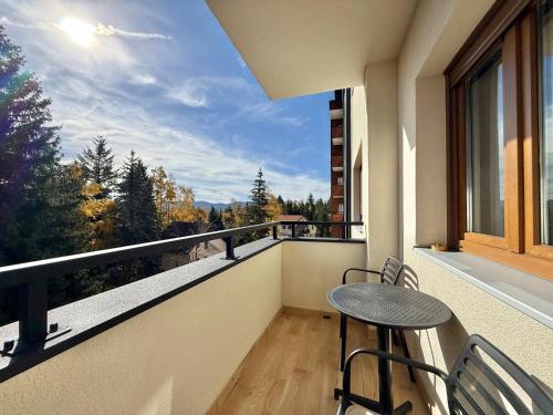 uma varanda com mesa e cadeiras e vista em Zlatibor Prestige Apartman 18 em Zlatibor