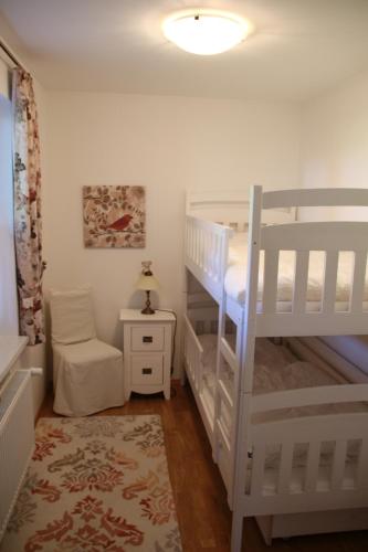 a bedroom with two bunk beds and a chair at Haus der Berge in Braunlage