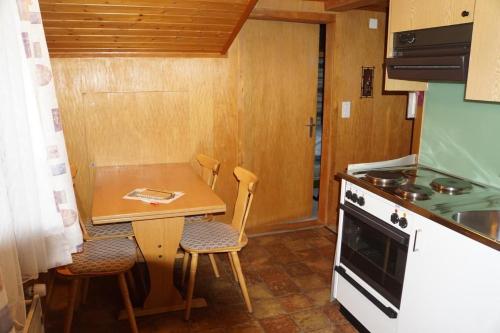 eine kleine Küche mit einem kleinen Tisch und Stühlen in der Unterkunft Bühlengasse 6 in Grindelwald