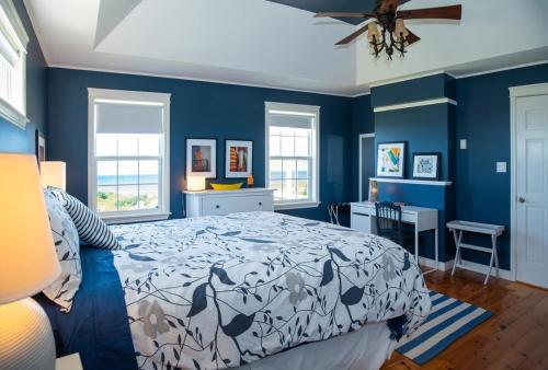 a blue bedroom with a bed and blue walls at Summer By The Sea Beach House in Saint Peters
