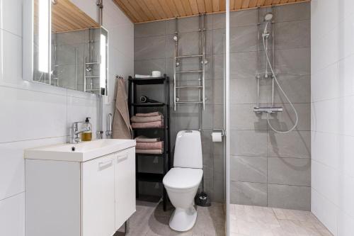 a bathroom with a shower and a toilet and a sink at Stylish, 450 m walk to the Estonian ferry, Free parking and balcony in Helsinki