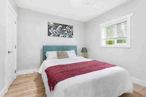 a white bedroom with a large bed and a window at Lovely Coach House in Langley with Queen Beds Pkg in Langley