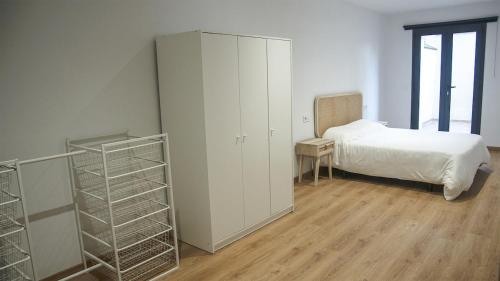 a bedroom with a bed and a white cabinet at Cal Perot Apartamento turístico en Les Borges Blanques in Les Borges Blanques 