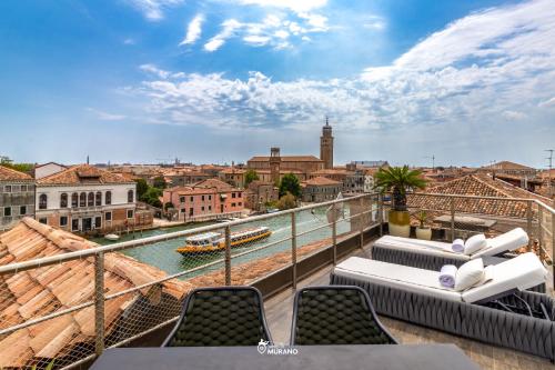 a balcony with chairs and a view of the water at MURANO Suites - Venezia in Murano