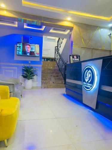 um saguão com uma parede azul e uma TV em Triple J Universal Hotel and Suites em Asaba