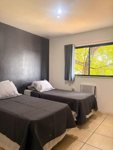 ein Schlafzimmer mit zwei Betten und einem Fenster in der Unterkunft Stratus Centro Hotel in Volta Redonda