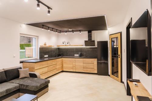 Il dispose d'une cuisine et d'un salon avec un canapé et un réfrigérateur. dans l'établissement Domki u Duszy Wielka Dusza, à Brenna